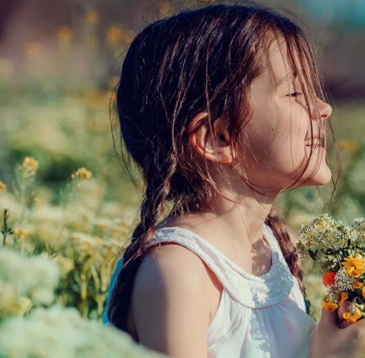 Kind auf einer Blumenwiese